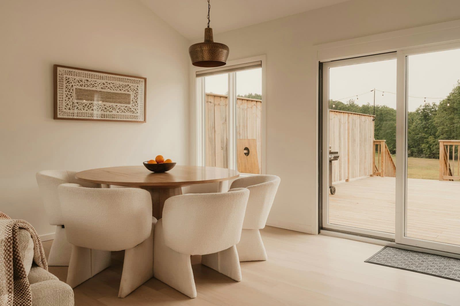 Dining area with a round oak table beside new sliding glass doors that open onto the deck.
